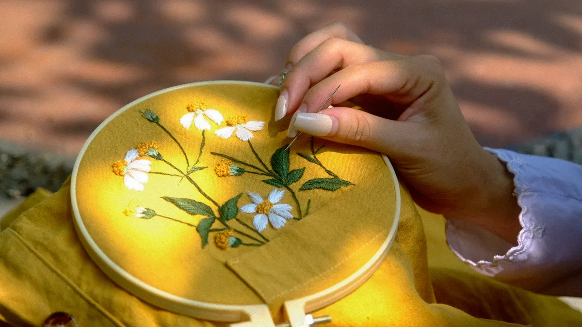 Basic embroidery stitches every beginner should learn Hand stitching flowers on fabric in an embroidery hoop
