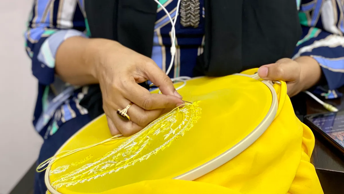 Basic embroidery stitches every beginner should learn Person embroidering on bright yellow fabric in a hoop
