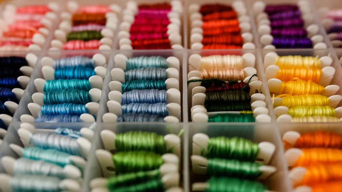 Assorted colorful thread spools in a storage box