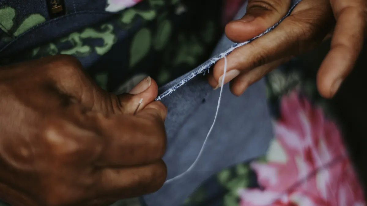 How to do a backstitch cleanly for outlines and seams Hands stitching fabric by hand with thread